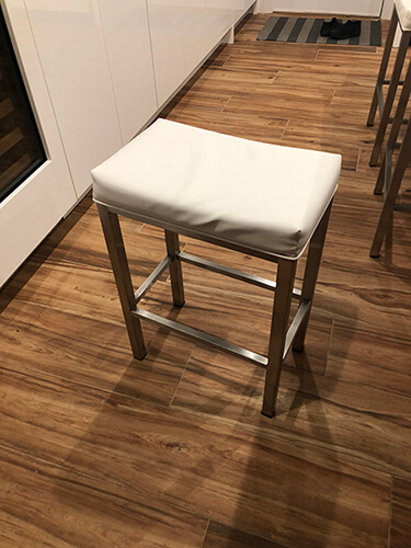 Wesley Allen's Seattle Backless Saddle Barstool in Stainless Steel Metal Finish and White Seat Cushion - in Kitchen with hardwood flooring