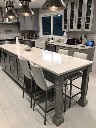 Amisco's Linea Upholstered Bar Stools with Back in Silver Metal Finish and Gray Upholstery - Shown in Transitional Gray Kitchen