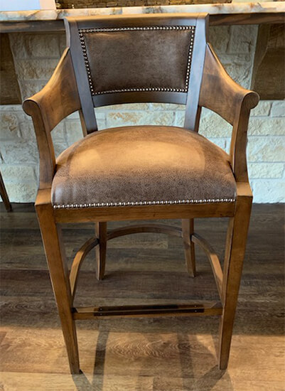 Fairfield's Gilroy Upholstered Wooden Brown Bar Stool with Arms and Nailhead Trim